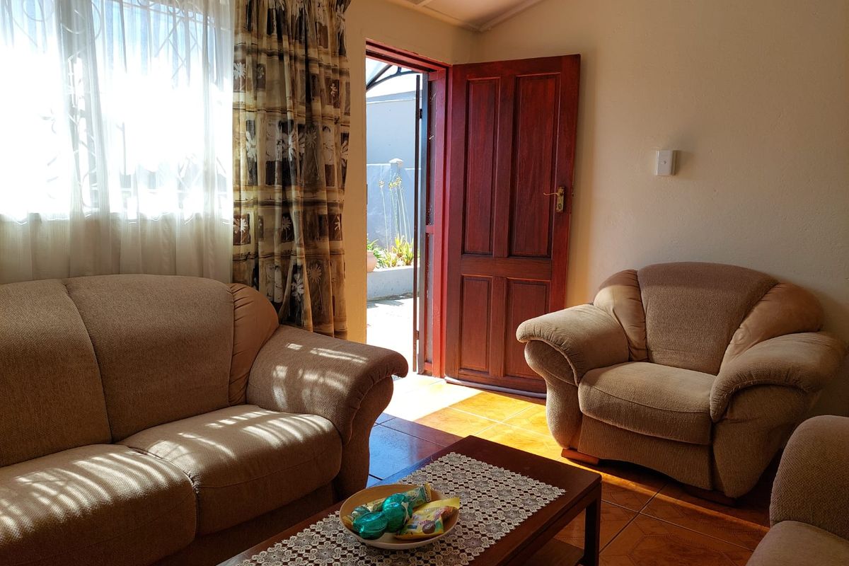 A living room featuring tiled flooring and direct access to an outdoor area through a timber door.