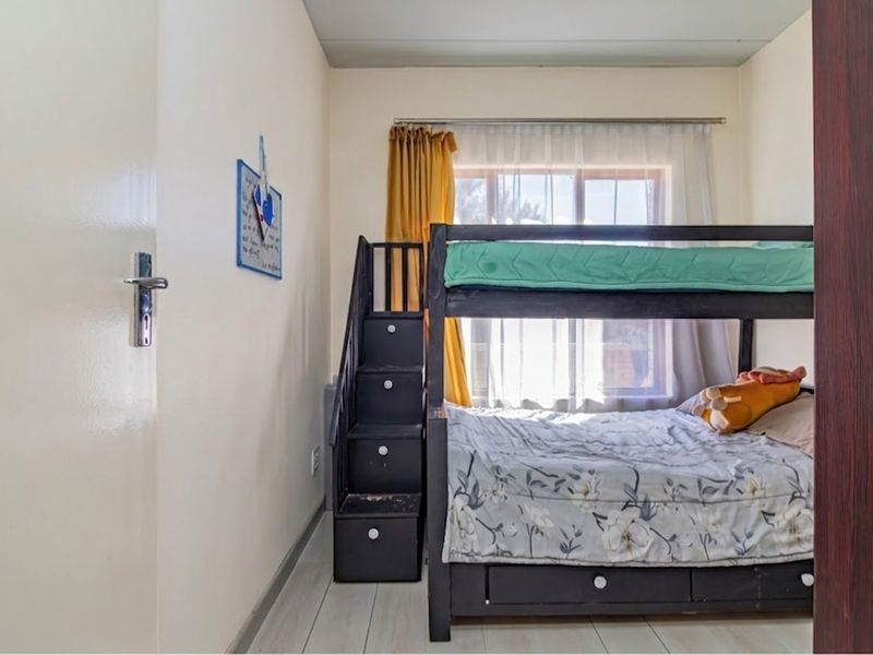 A functional bedroom featuring a window with natural light and standard interior finishes.