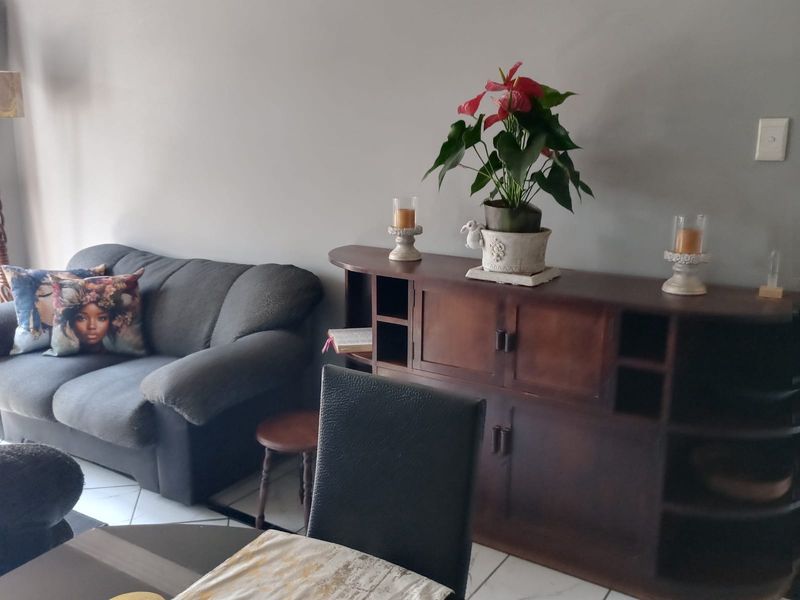 A living room area featuring tiled flooring and neutral wall finishes, providing a functional space for relaxation.