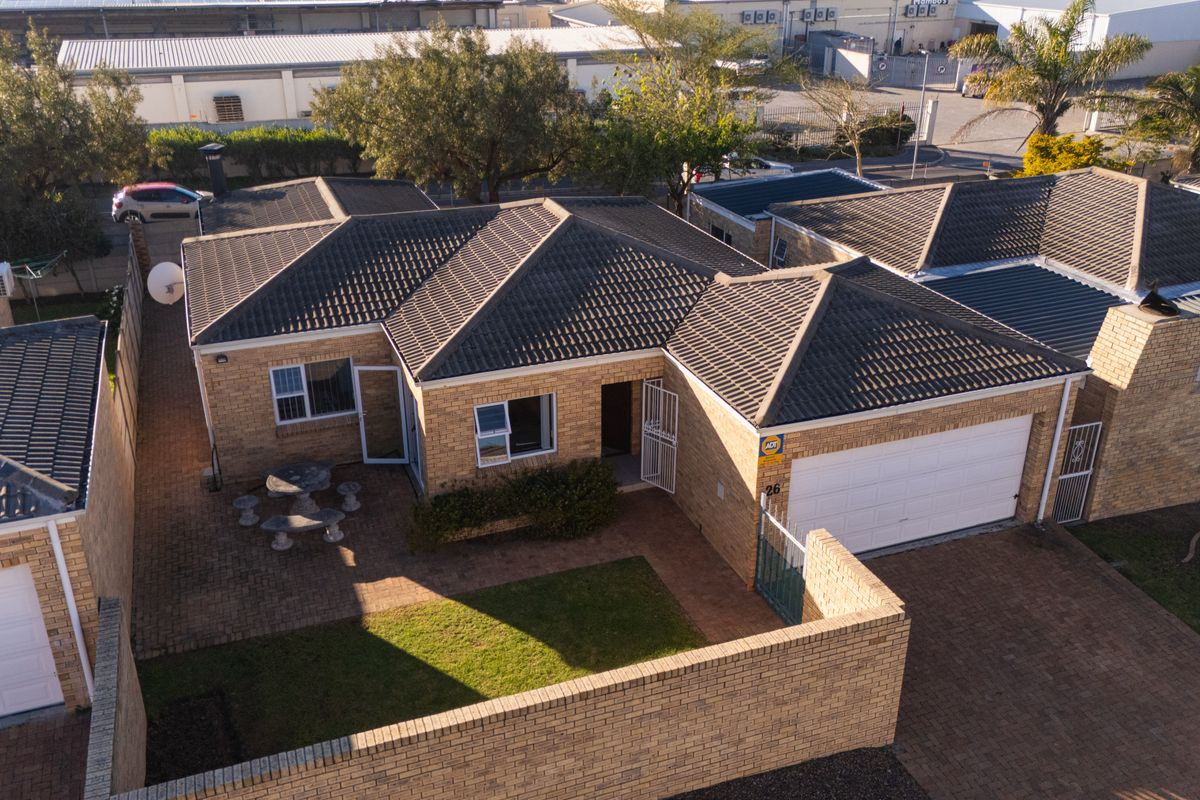 Aerial view of a face brick residential property featuring a tiled roof, paved driveway, single garage, and a private front garden area.