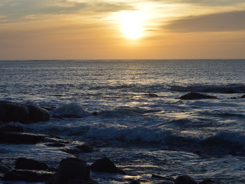 A scenic view of the ocean at sunset, showcasing the natural landscape and coastal horizon.