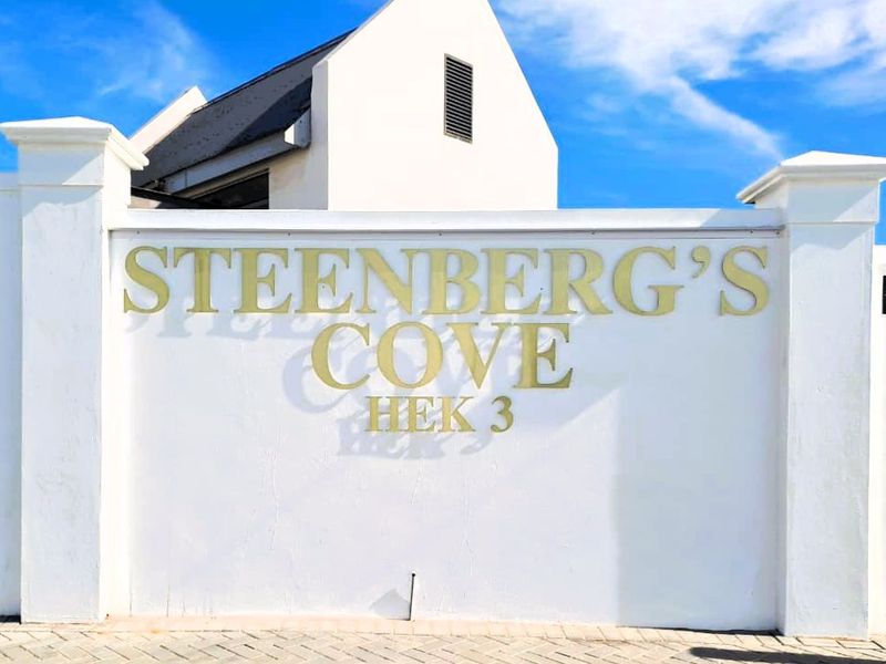 A clear view of the Steenberg's Cove estate entrance signage mounted on a well-maintained white boundary wall.