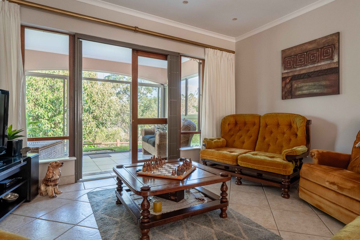 A bright living room featuring tiled flooring and large sliding glass doors that provide direct access to an outdoor patio area.