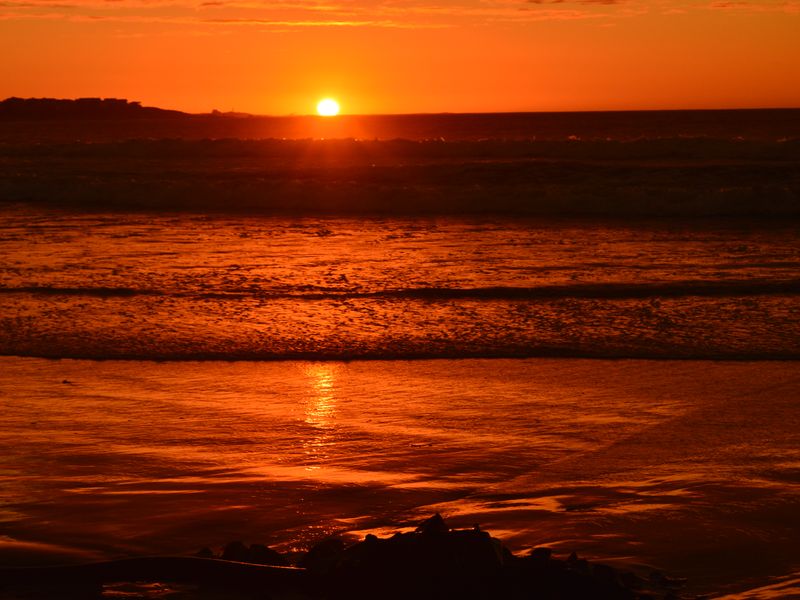 A scenic sunset view over the ocean, highlighting the natural landscape and coastal setting of the property.
