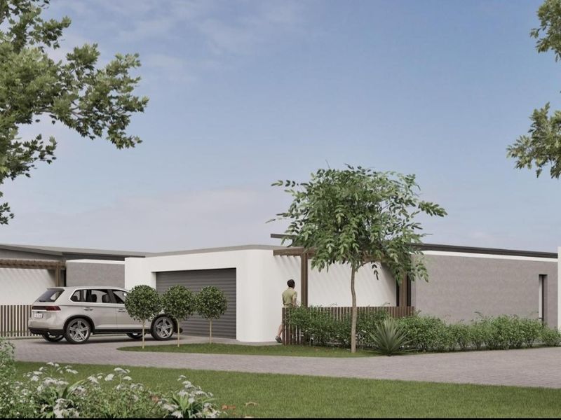 Front elevation of a modern cluster home featuring a paved driveway, garage, and timber architectural detailing.