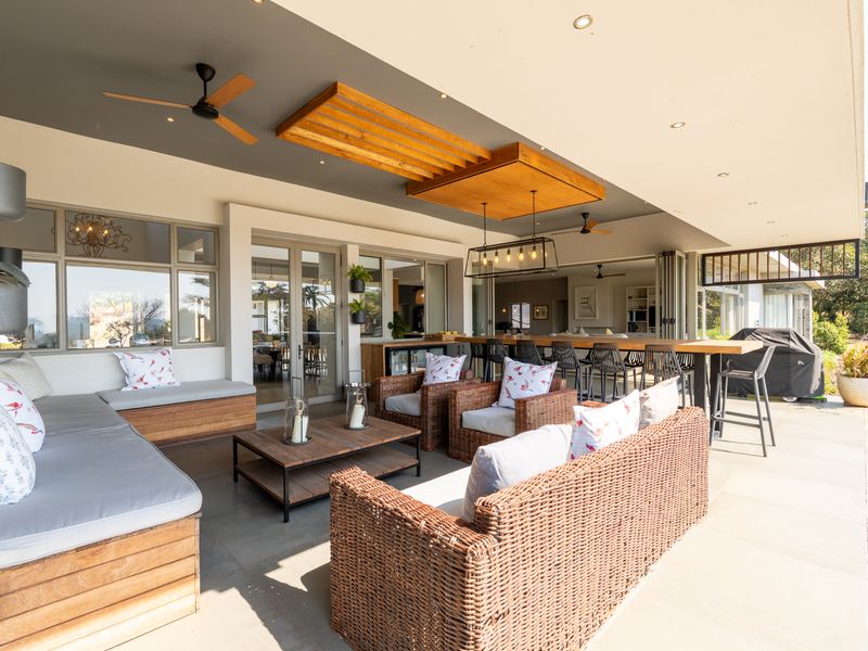 Spacious covered patio featuring a timber ceiling detail, recessed lighting, built-in seating, and an integrated outdoor bar area, perfect for alfresco entertaining.