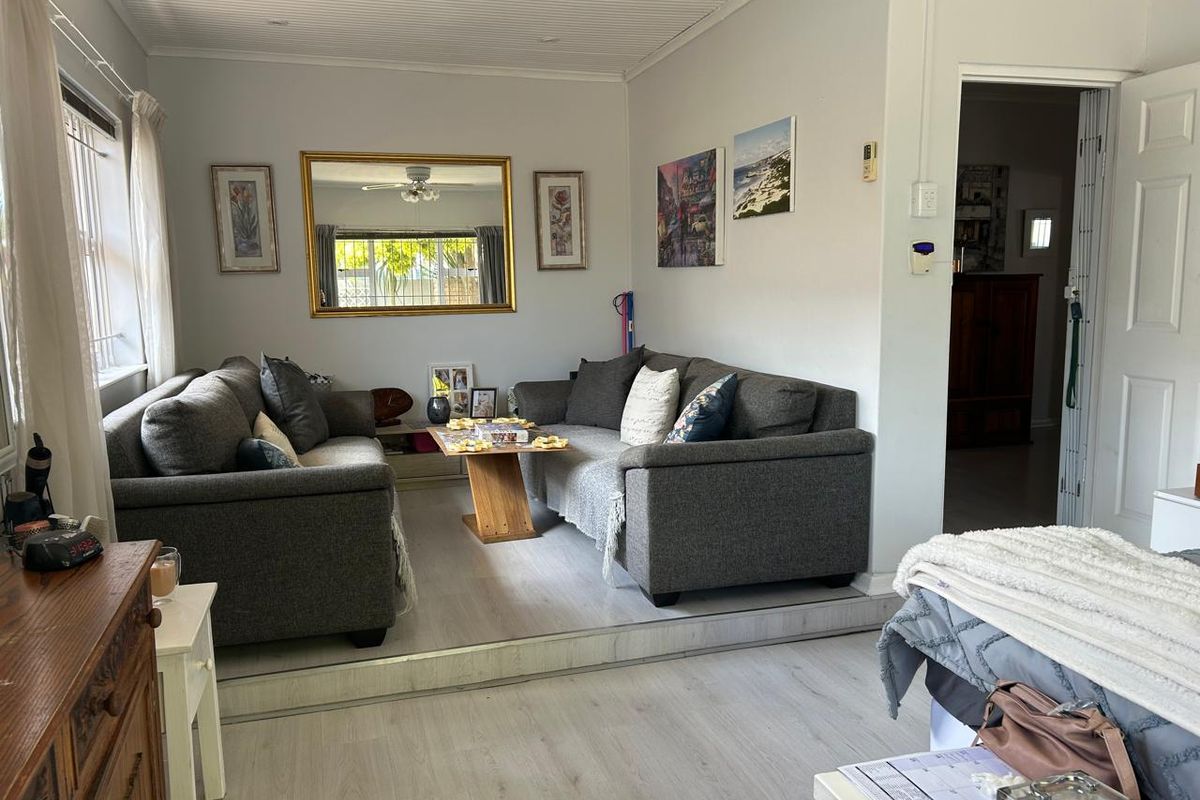 A living room featuring a raised floor platform, laminate flooring, and a beadboard ceiling, providing a distinct sunken-style seating area.