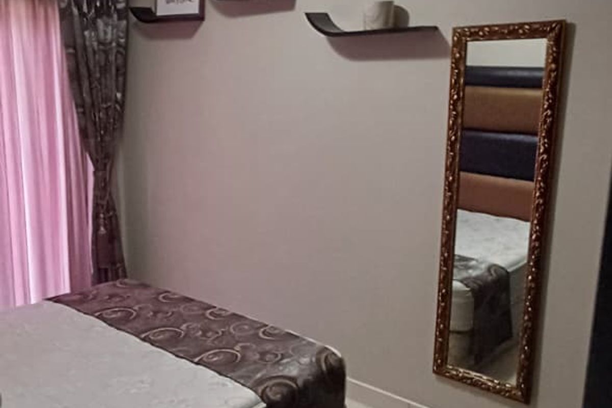 A bedroom featuring tiled flooring and decorative ceiling cornicing, providing a neutral base for personal styling.