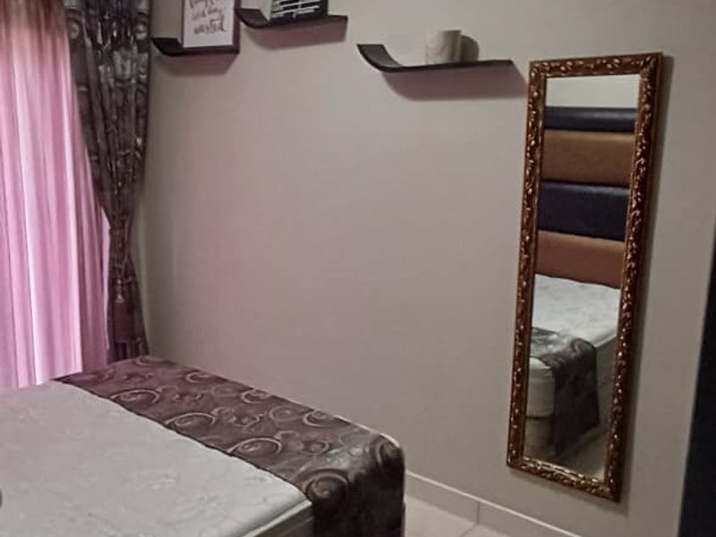 A bedroom featuring tiled flooring and decorative ceiling cornicing, providing a neutral base for personal styling.