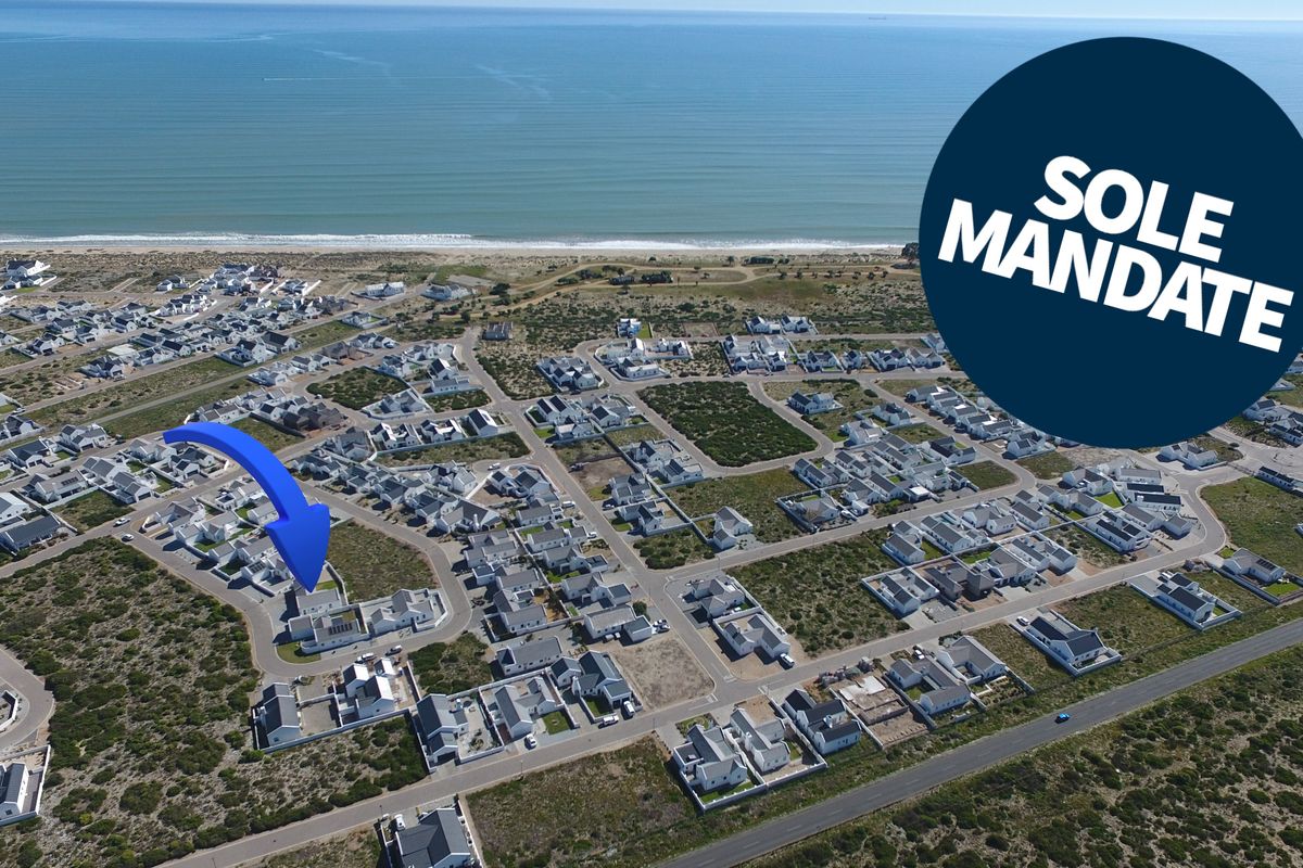 Aerial view of a coastal residential estate, highlighting the property's proximity to the beach and surrounding neighborhood layout.