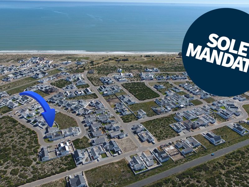 Aerial view of a coastal residential estate, highlighting the property's proximity to the beach and surrounding neighborhood layout.