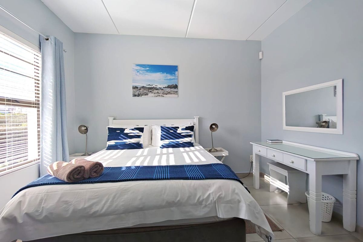 A well-maintained bedroom featuring tiled flooring and natural light through window blinds, offering a clean and comfortable living space.