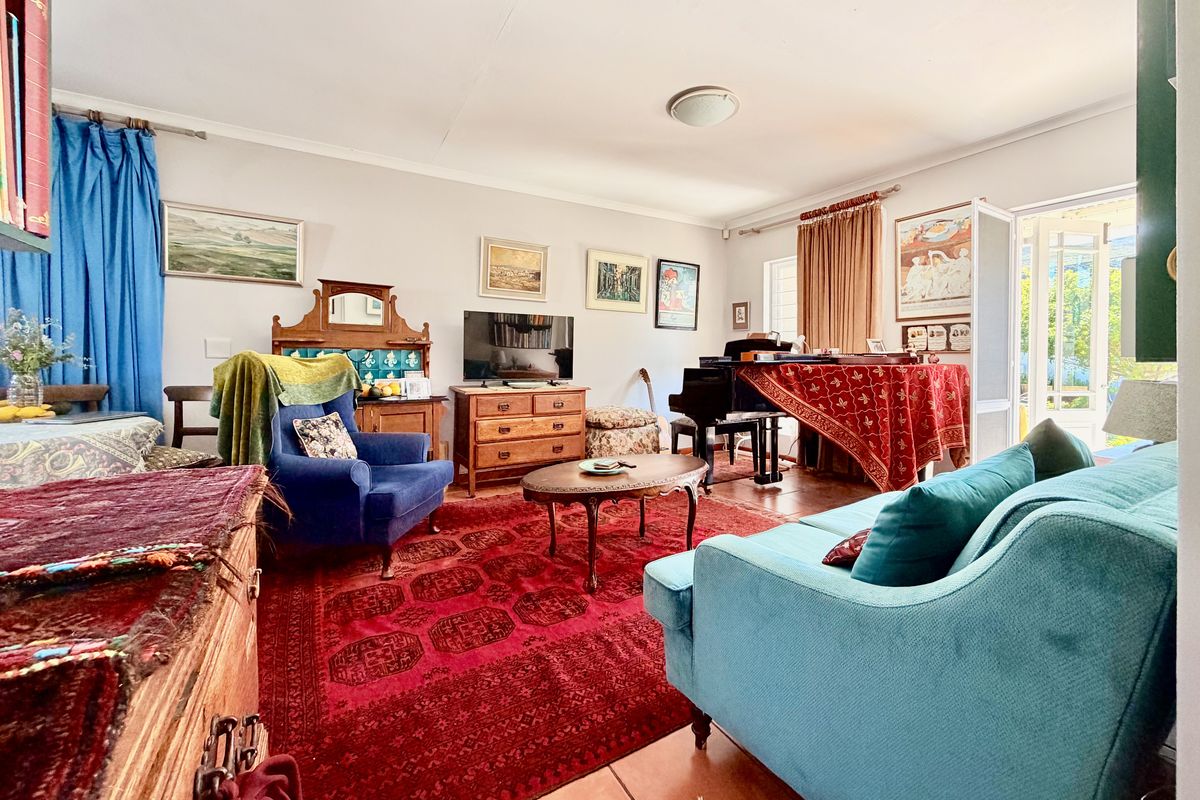 A spacious living room featuring tiled flooring and a sliding glass door providing access to the outdoor area.
