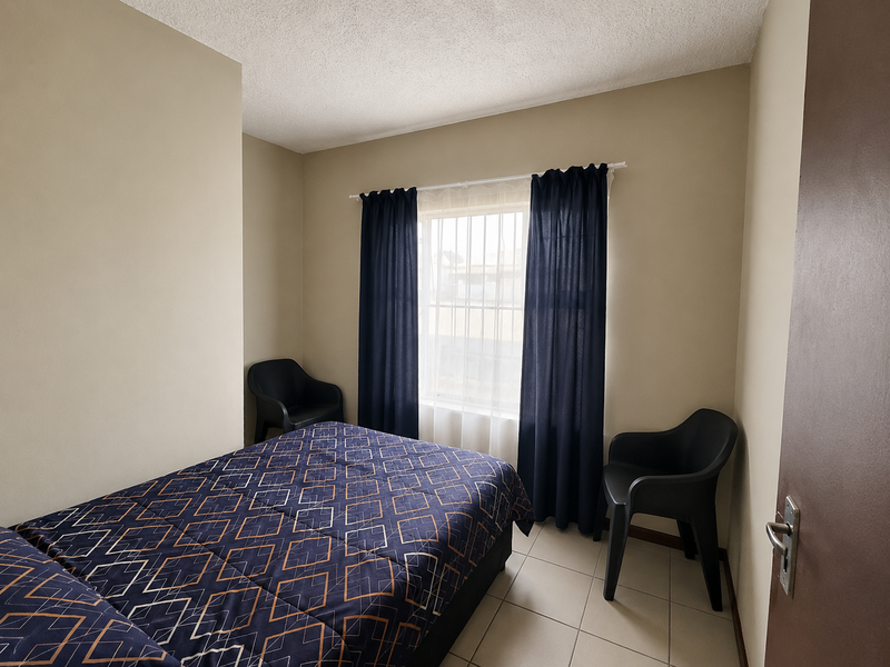 A bedroom featuring neutral wall tones, tiled flooring, and a window with dark curtains.