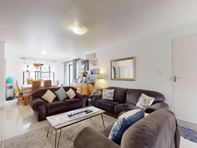 Spacious open-plan living and dining area featuring neutral tiled flooring and bright, functional lighting throughout the main living space.