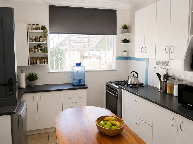 A functional kitchen featuring white cabinetry, dark countertops, a gas stove, and a tiled backsplash, providing a clean and practical workspace.