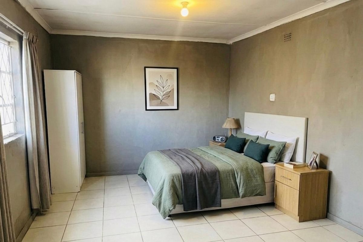 A bedroom featuring tiled flooring and plain walls, offering a functional space with basic finishes.