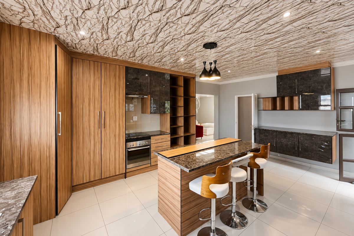 Modern kitchen featuring wood-grain and dark marble-finish cabinetry, a central island with breakfast bar, built-in appliances, and a distinctive marble-patterned ceiling.
