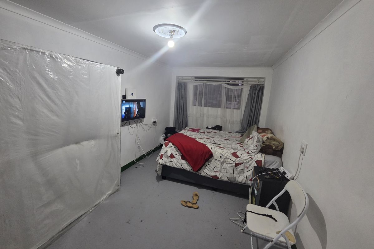 A bedroom featuring a window, cove cornicing, and electrical points. The room requires cosmetic updates to the flooring and general finishes.