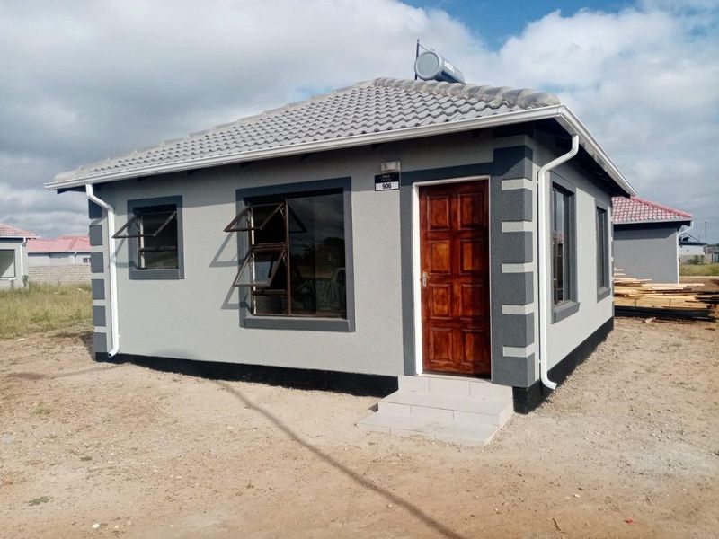 A modern, well-maintained single-story house featuring a tiled roof, solar geyser, and clean exterior finishes with aluminium window frames.