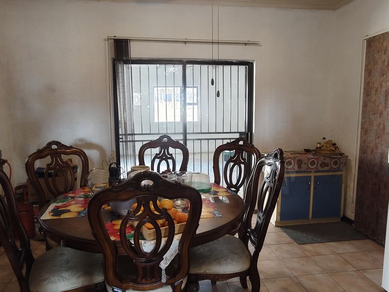 Open plan dining and kitchen area featuring tiled flooring and a sliding glass door leading to the exterior.