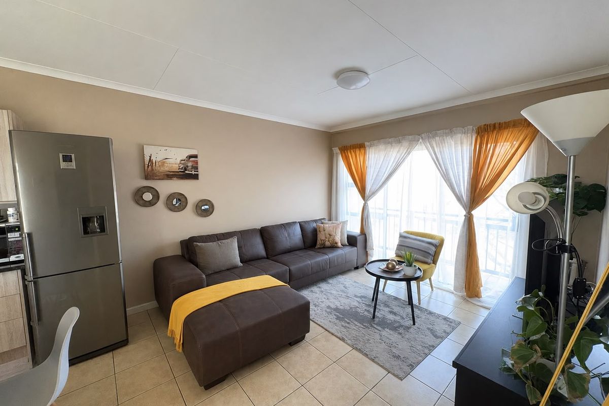 Open plan living area featuring tiled flooring and a large sliding glass door providing natural light.