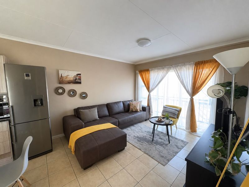 Open plan living area featuring tiled flooring and a large sliding glass door providing natural light.