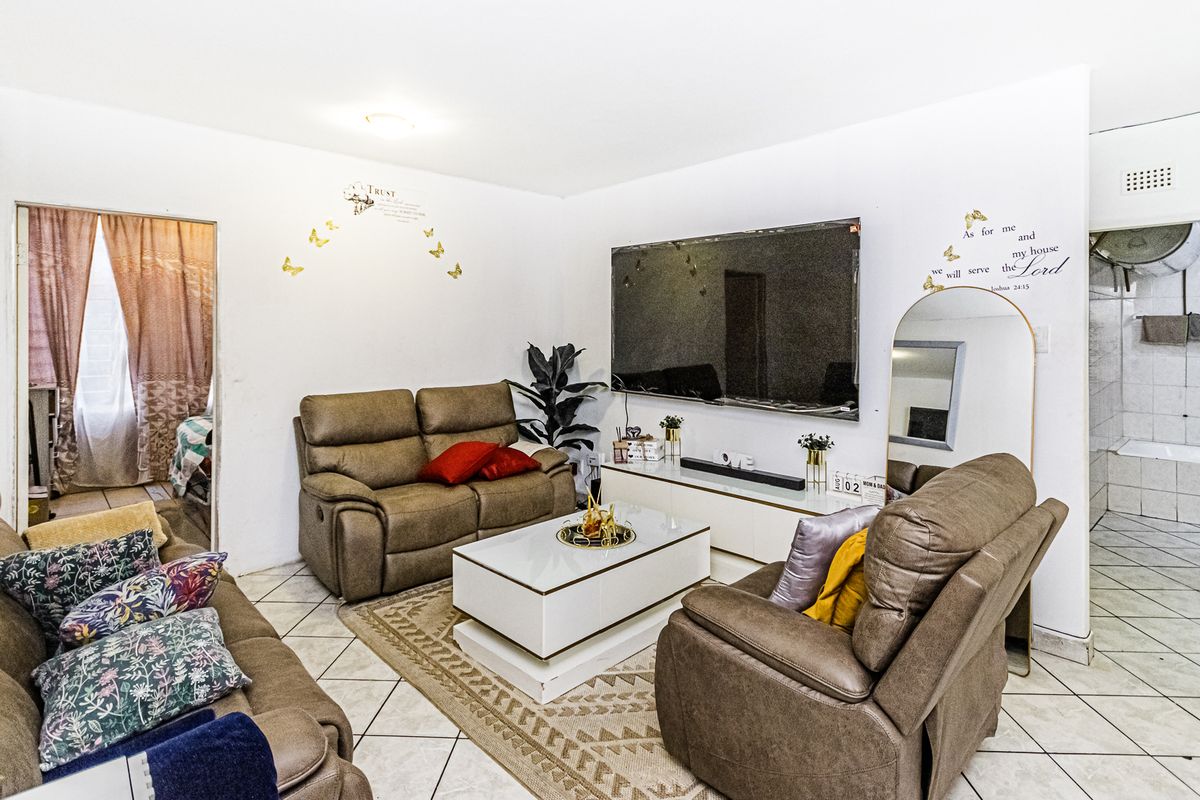 A living room featuring tiled flooring and direct access to adjacent rooms, providing a functional layout for daily living.