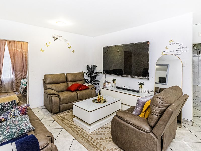 A living room featuring tiled flooring and direct access to adjacent rooms, providing a functional layout for daily living.