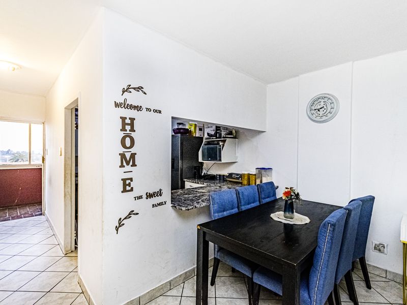 Open plan dining area featuring tiled flooring and a convenient pass-through window connecting to the kitchen space.