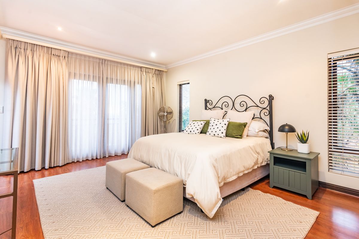 Spacious bedroom featuring hardwood flooring, crown molding, recessed lighting, and large sliding glass doors providing access to the exterior.