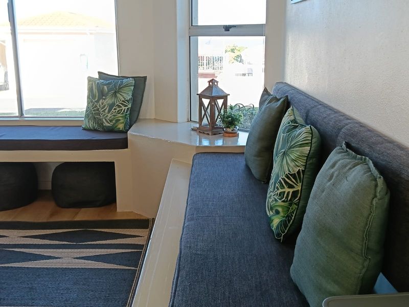 A cozy living area featuring custom built-in bench seating positioned under large windows, providing a bright and functional space.