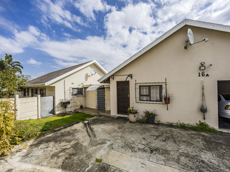 Front exterior view of the property featuring a concrete driveway, security gate, and integrated garage access.