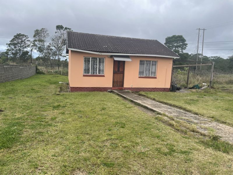 Front view of a detached single-story house featuring a tiled roof, security bars on windows, and a concrete pathway leading to the entrance.