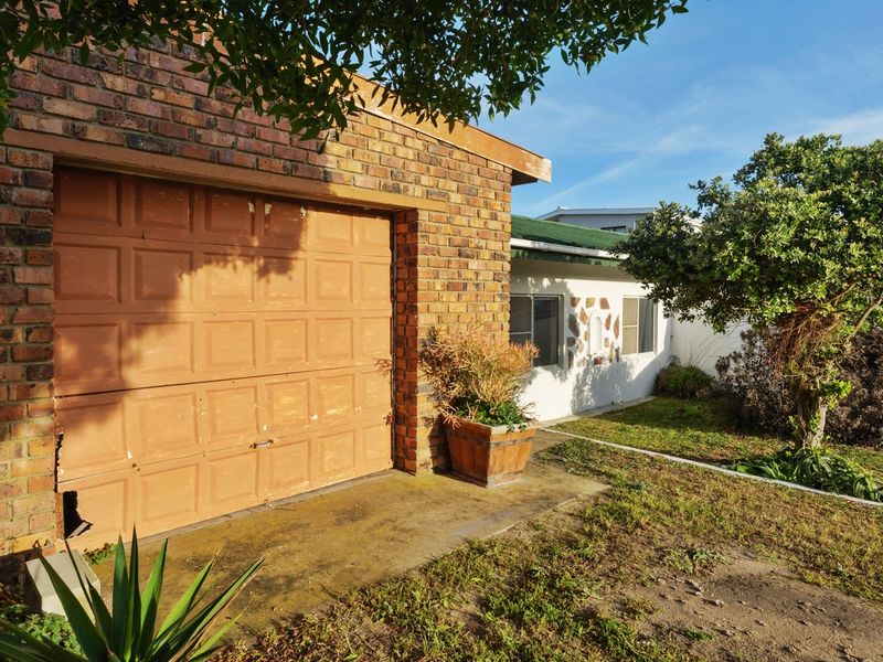 Front exterior view of the property featuring a brick facade, a single garage, and a paved driveway area.