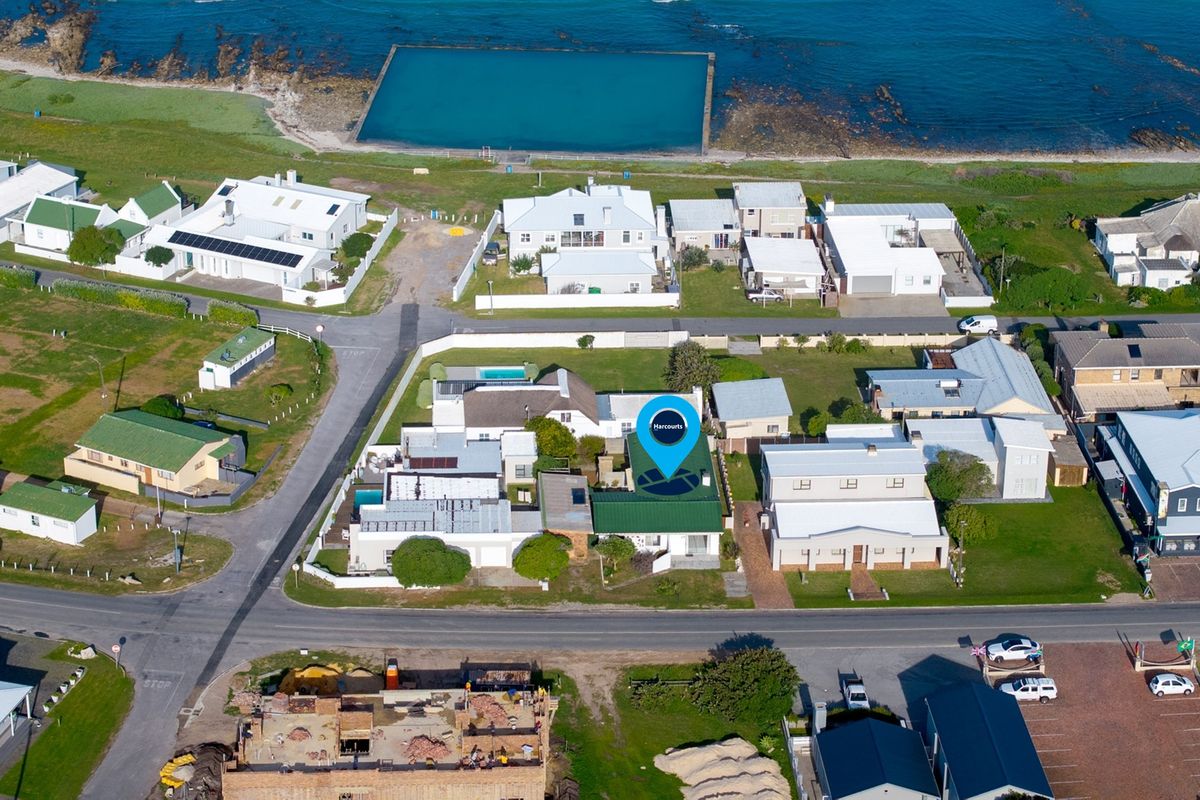 An aerial view of the coastal residential property, highlighting its prime location near the ocean and local tidal pool.