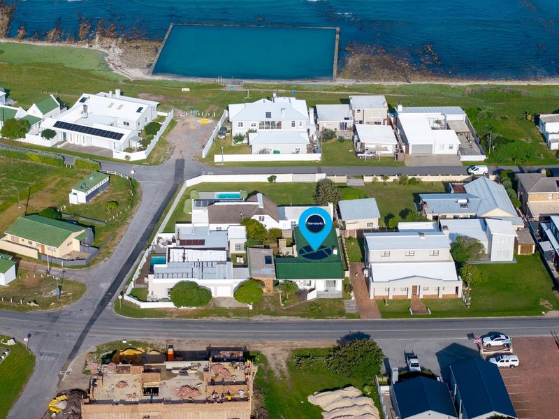 An aerial view of the coastal residential property, highlighting its prime location near the ocean and local tidal pool.