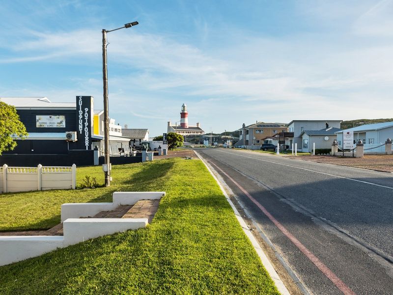 A clear street view showing the local neighbourhood approach with a prominent lighthouse in the distance.