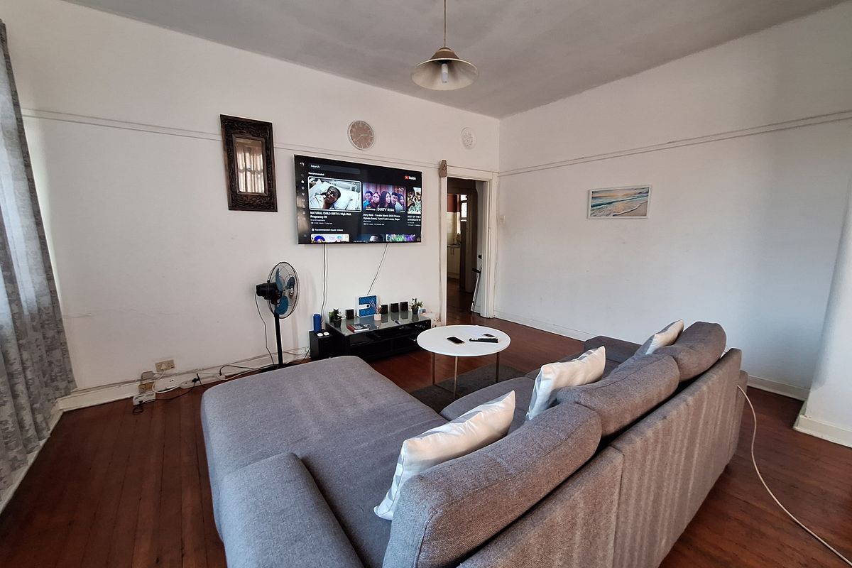 A living room featuring original hardwood flooring and classic picture rails, offering a blank canvas for potential cosmetic updates and interior design improvements.