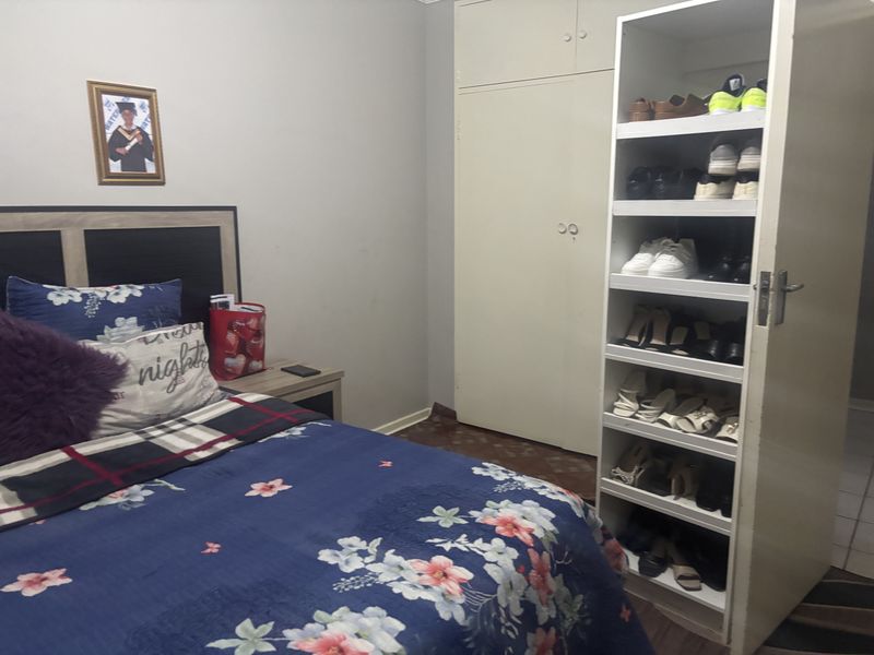 A bedroom featuring built-in wardrobe storage and parquet flooring, providing a functional sleeping space within the apartment.