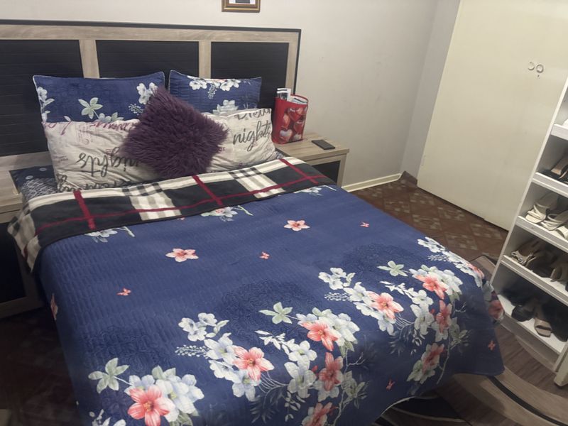 A bedroom featuring laminate flooring and a built-in wardrobe with open shelving.