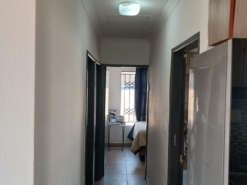 A functional hallway featuring tiled flooring and access to adjacent rooms, providing a clean transition space within the home.