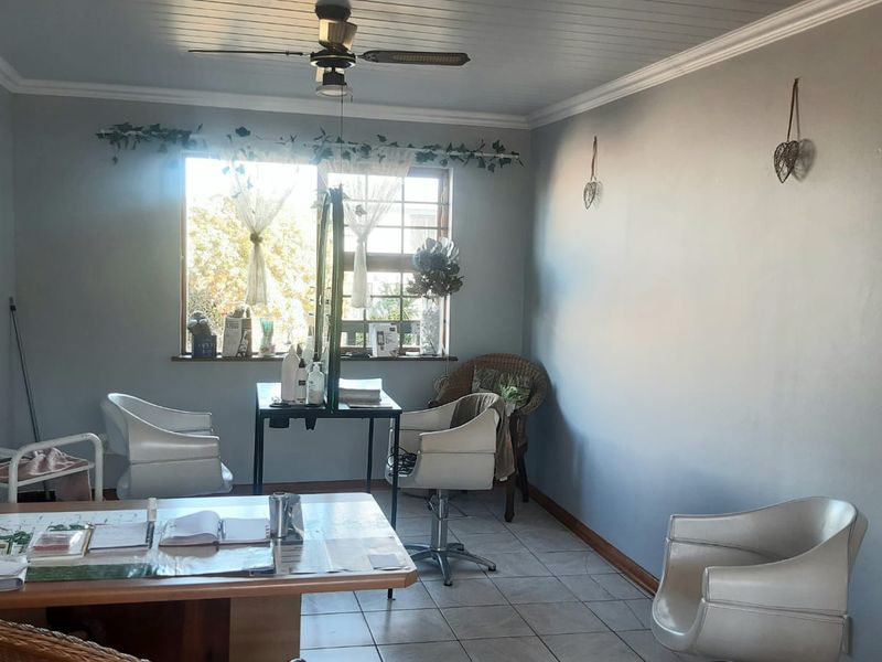 A functional office space featuring tiled flooring, a ceiling fan, and crown molding, providing a versatile area for work or professional use.