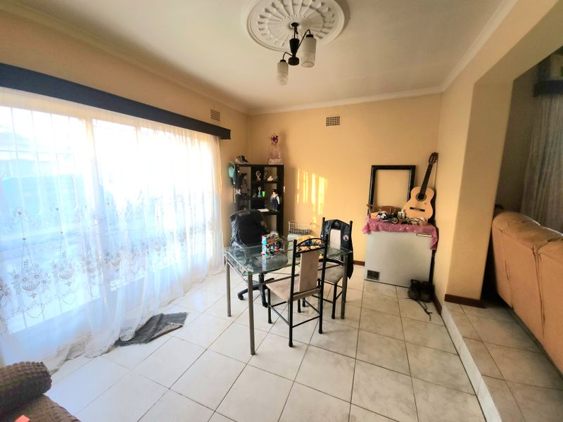 Dining area featuring tiled flooring, a ceiling rose, and a large sliding glass door providing natural light.
