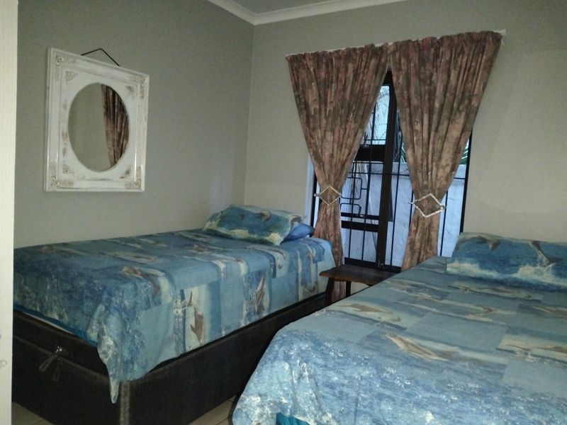 A bedroom featuring neutral wall finishes, a window with security bars, and coving detail.