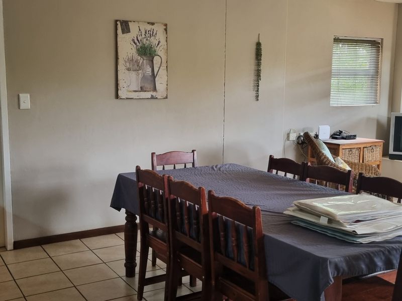 A dining room featuring tiled flooring and venetian blinds, providing a functional space for meals.