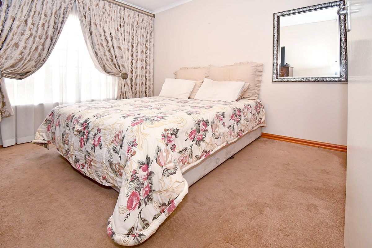 A carpeted bedroom featuring neutral wall finishes, curtain rails, and skirting boards, providing a functional and comfortable sleeping space.
