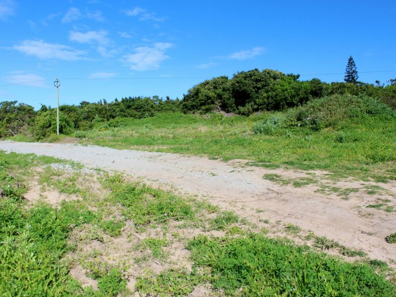 A view of the vacant residential land featuring an unpaved access road and existing utility infrastructure.