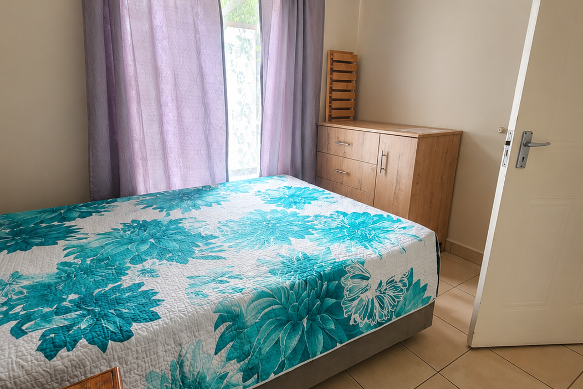 A bedroom featuring neutral wall tones, tiled flooring, and a coved ceiling, providing a functional and well-lit space.