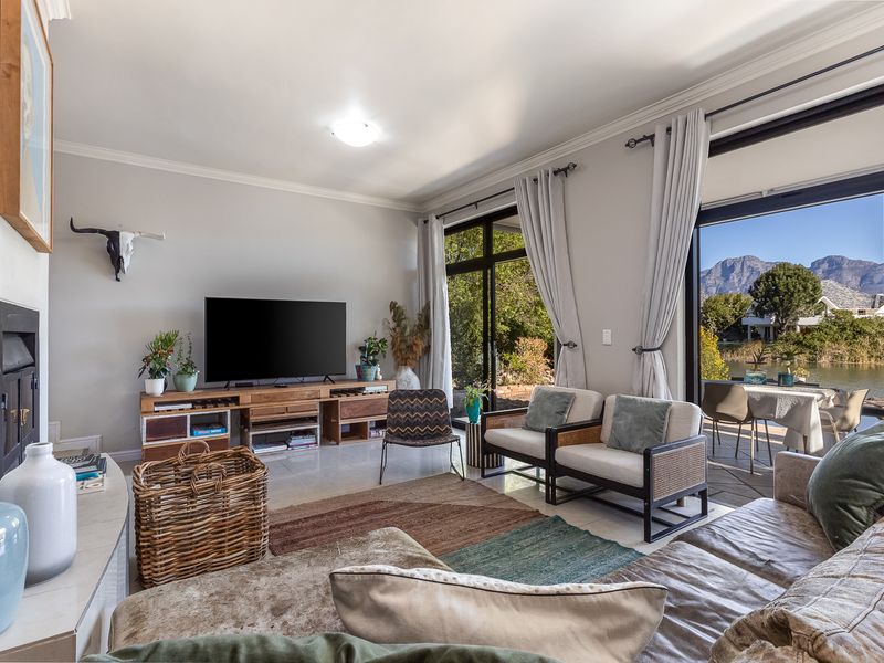 Spacious living room featuring a fireplace, tiled flooring, and large sliding glass doors that provide natural light and access to the outdoor patio area.